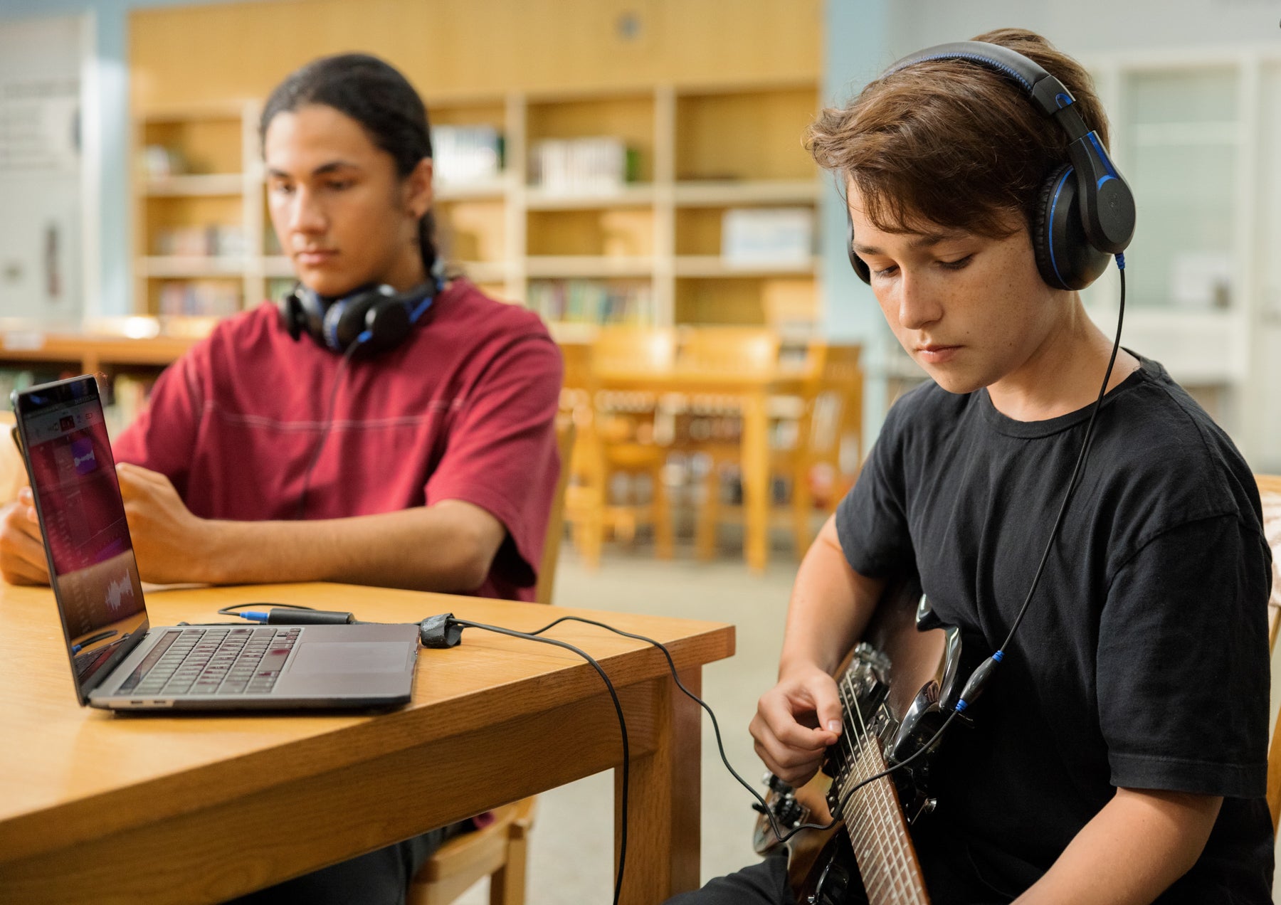 Students in a educational environment wearing TWT Audio DURO headsets while using Chromebooks to record music