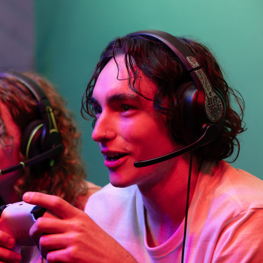 Male gamer engaged in competitive play, utilizing a 350XG Victory Gaming Headset with microphone, and holding a game controller.