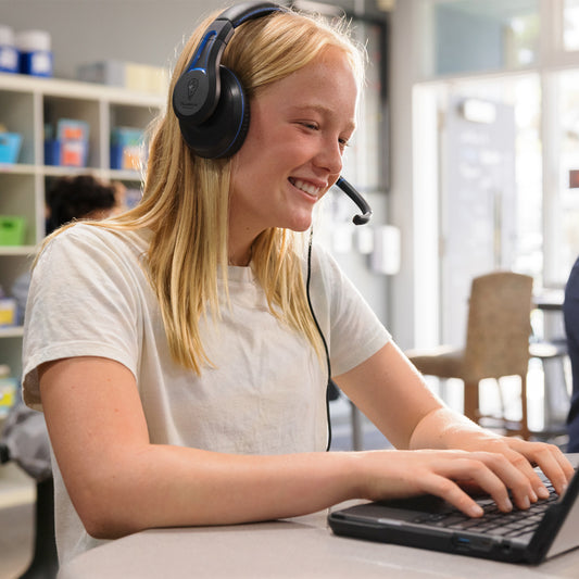 Women using TWT Audio headphones connected to a laptop are smiling at the screen